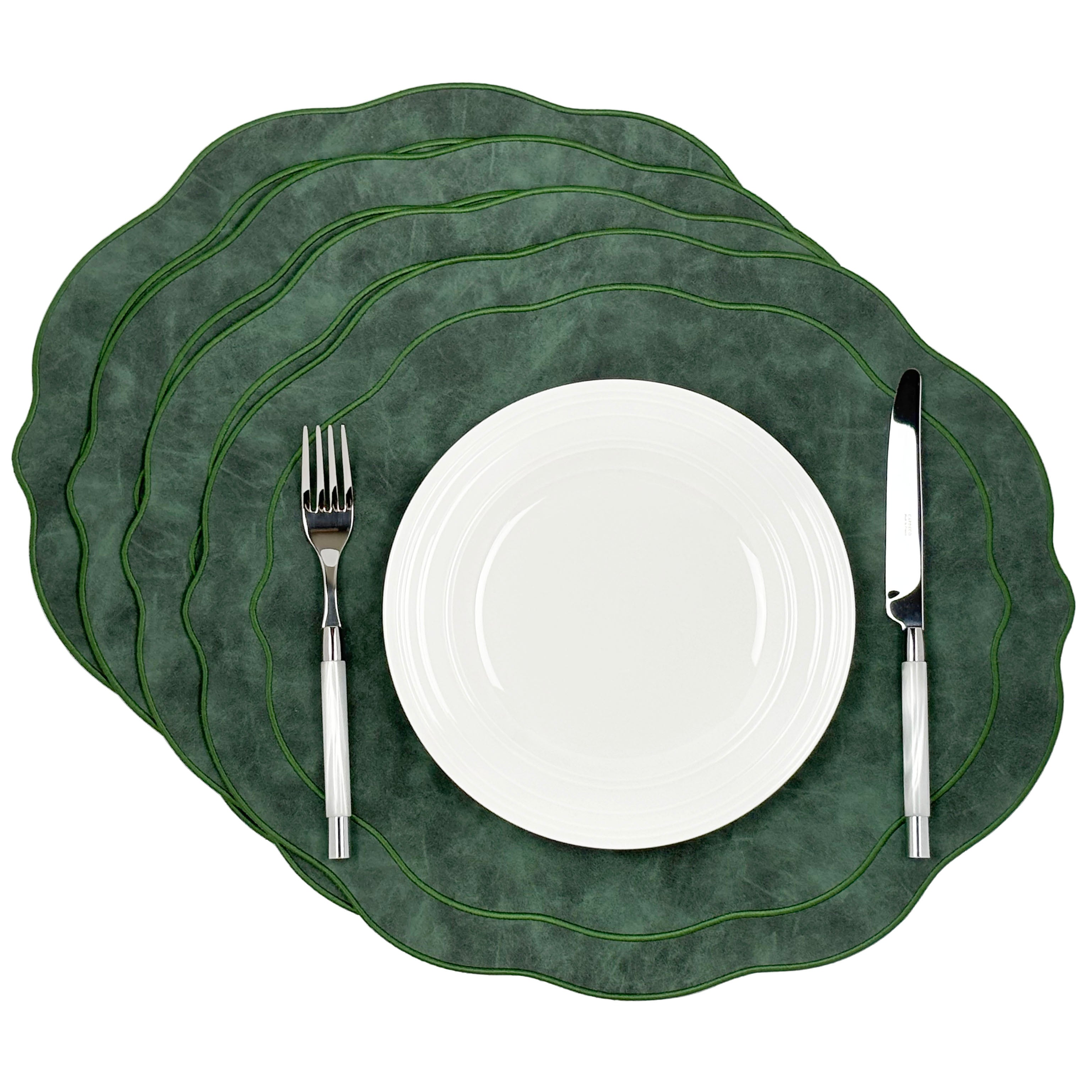Four green Melbourne scalloped faux leather placemats, stacked, included in the set