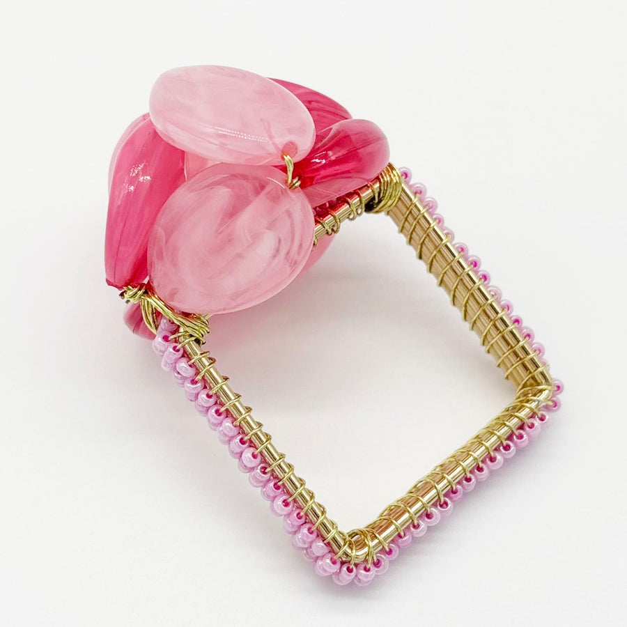 Close-up of the pink beaded Pebble Stone napkin ring included in the set