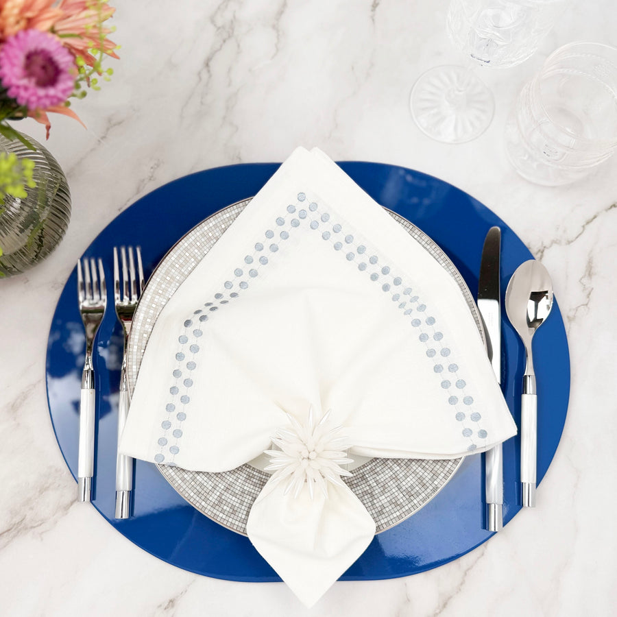 Blue Kelly lacquered wood placemat with a white napkin and patterned plate