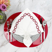 Red Kelly lacquered wood placemat with a red-and-white embroidered napkin and silver flatware