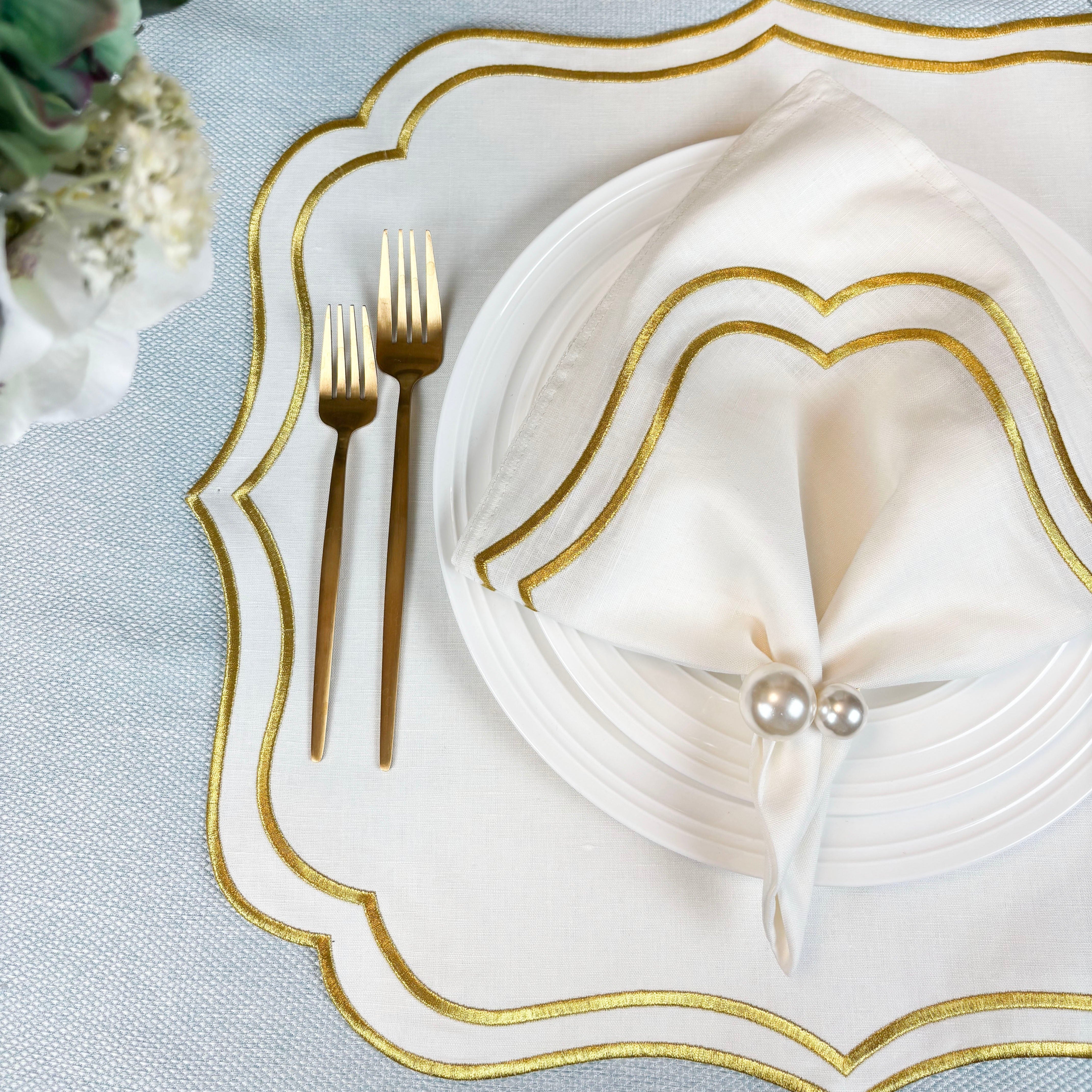 Ivory Gold embroidered napkin on an ivory Charlotte scalloped placemat with gold flatware
