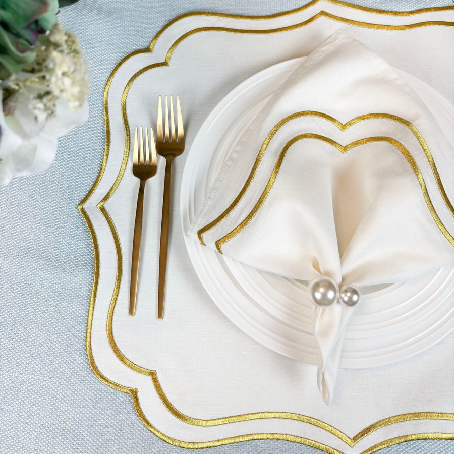 Ivory Gold embroidered napkin on an ivory Charlotte scalloped placemat with gold flatware