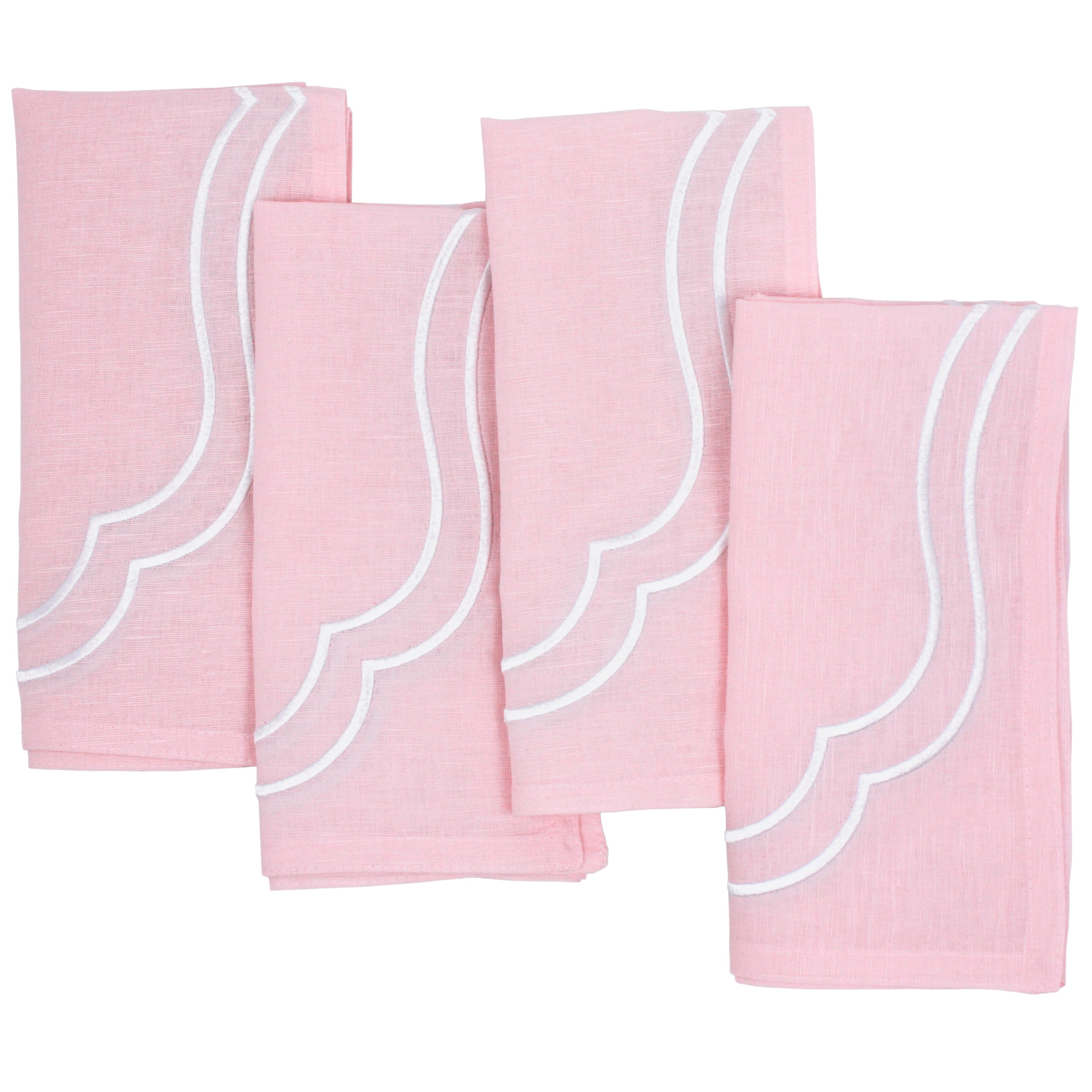 Four light pink Charlotte cotton linen napkins with white scallop embroidery, laid flat